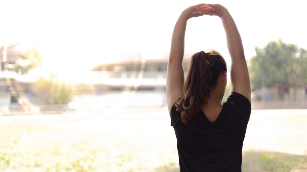 woman holding arms over her head, stretching