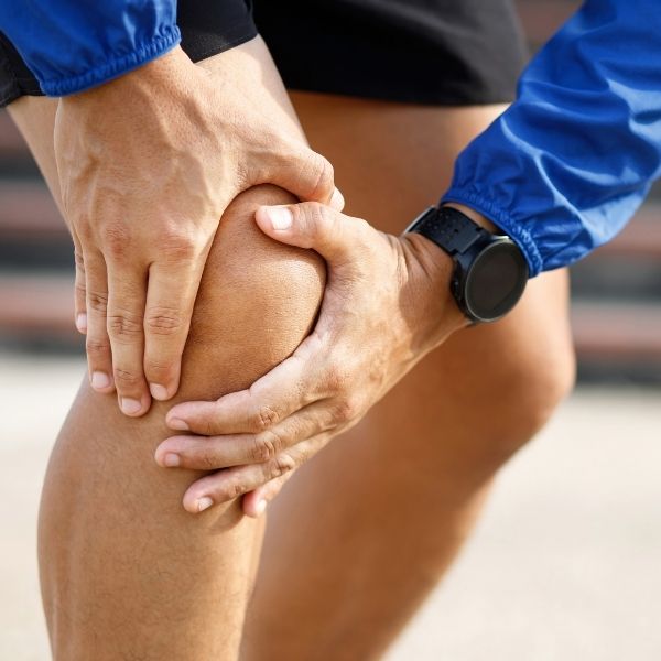 holding knee in pain