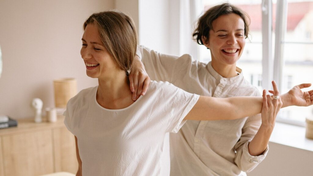 A stretchologist at Stretch U assists a client with a myofascial stretch in a bright, modern studio.
