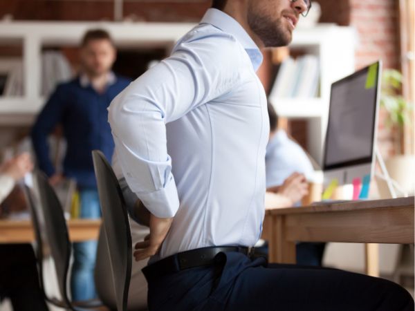 office worker rubbing painful back