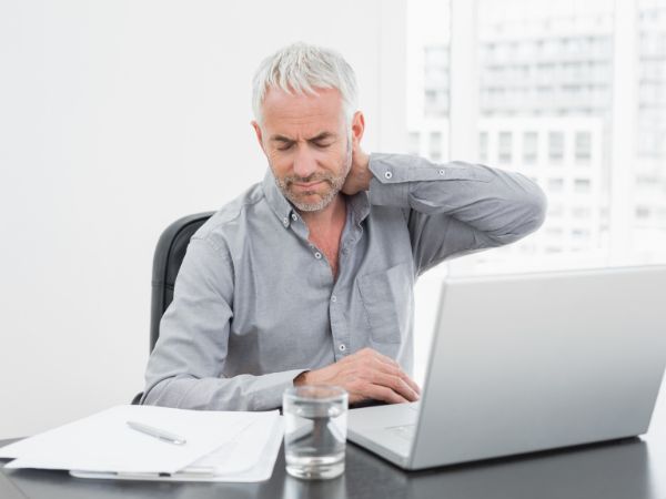 office worker rubbing painful neck